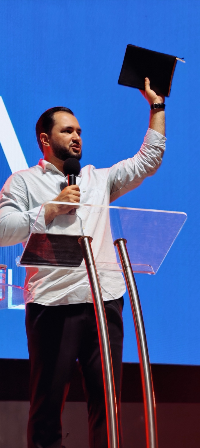 Pr. Marcelo Travagini ensinando com microfone e Bíblia